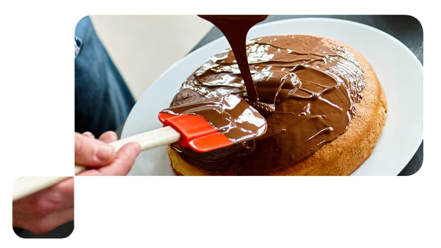 pessoa passando cobertura de chocolate no bolo