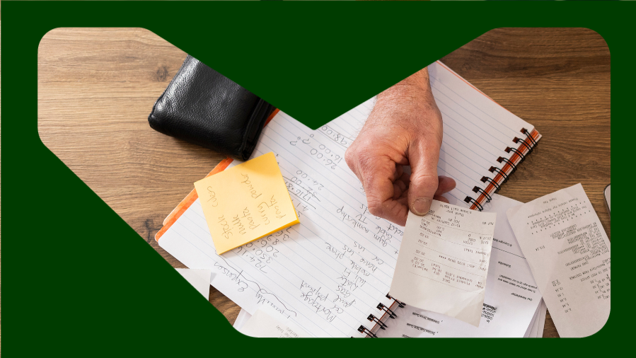 mão de uma pessoa mexendo em papeis, notas fiscais e caderno