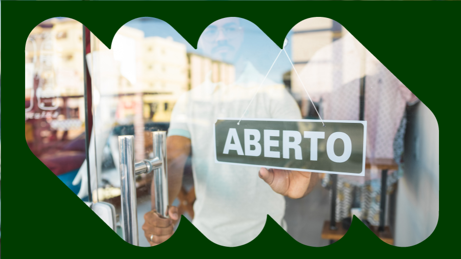 homem atrás de porta de vidro de loja com a placa aberto