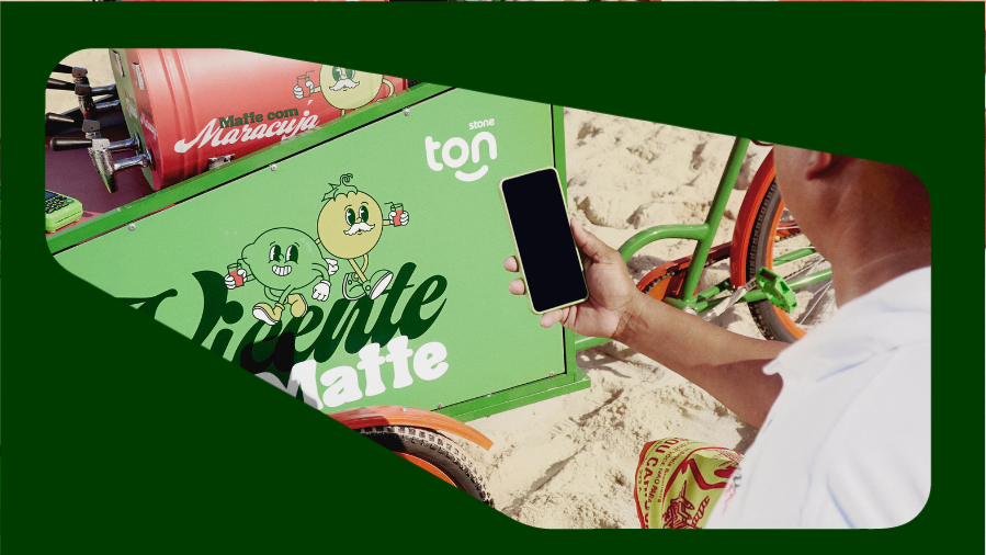 foto de carrinho de mate na areia e pessoa apontando o celular