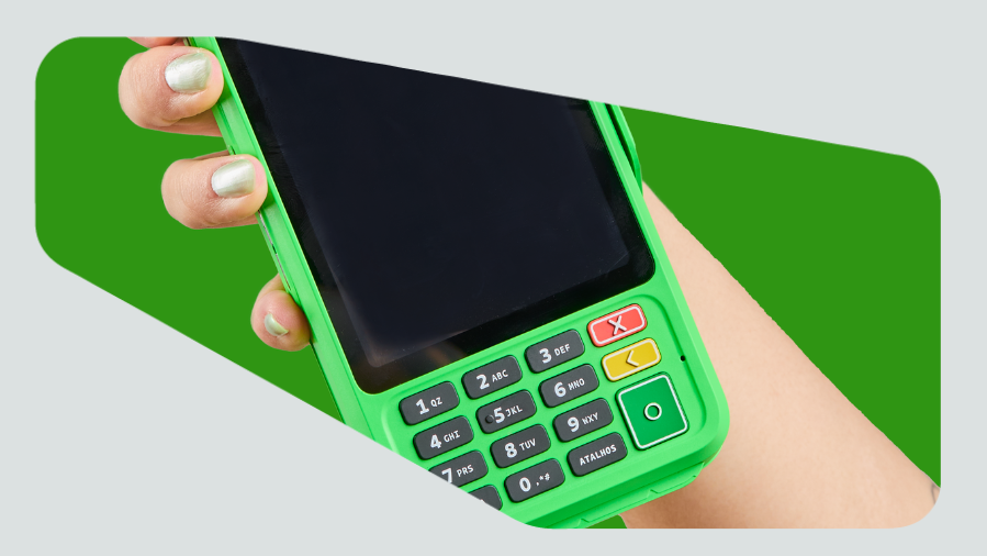 mão feminina segurando maquininha de cartão