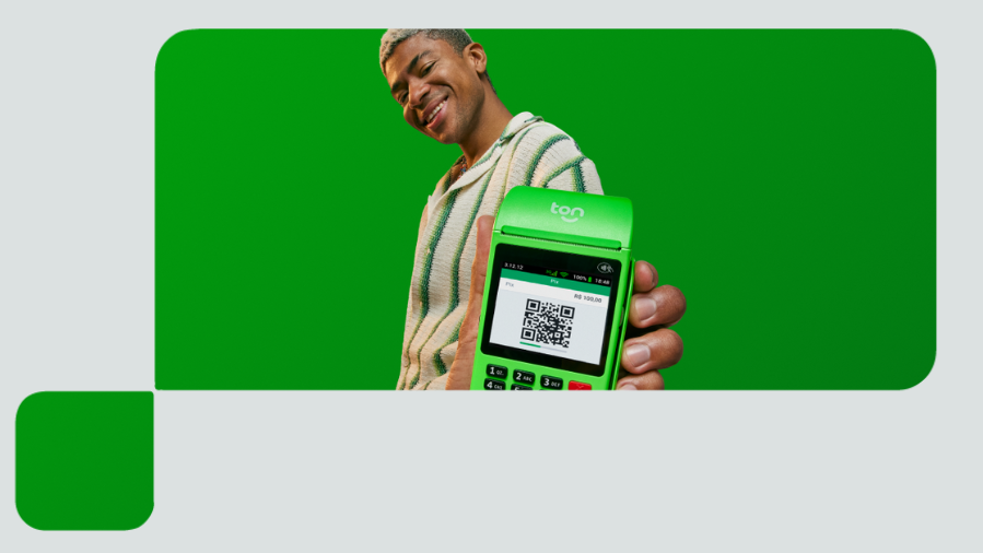 homem segurando maquininha de cartao com pix qr code
