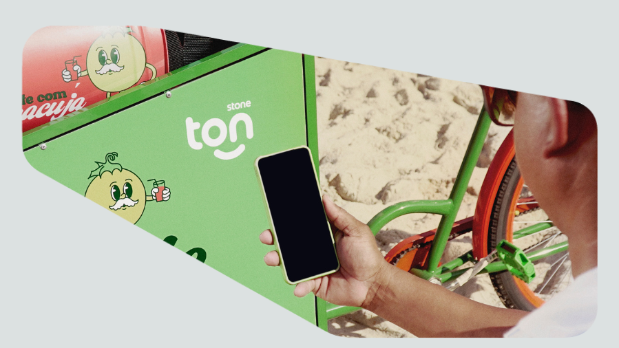 vendedor ambulante apontando celular para carrinho de mate na praia