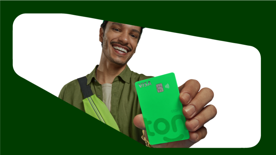 homem sorrindo segurando cartão ton