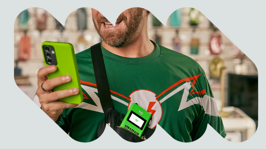 homem sorrindo mexendo no celular com capinha verde