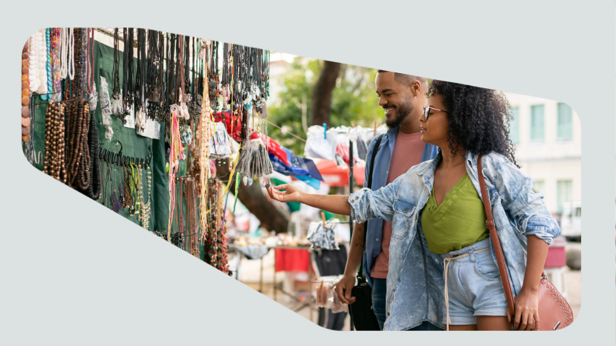 casal vendo barraquinha da feira com artesanato