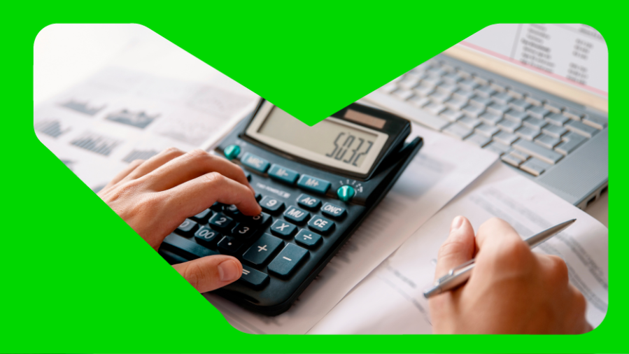 mão digitando em calculadora com papéis ao fundo