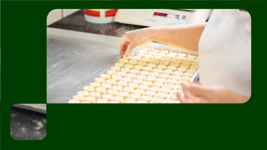 mão feminina colocando biscoitos para assar em assadeira