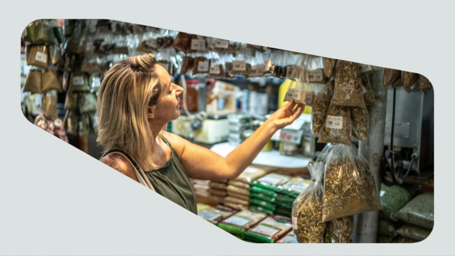 mulher escolhendo tempero em barraquinha de feira