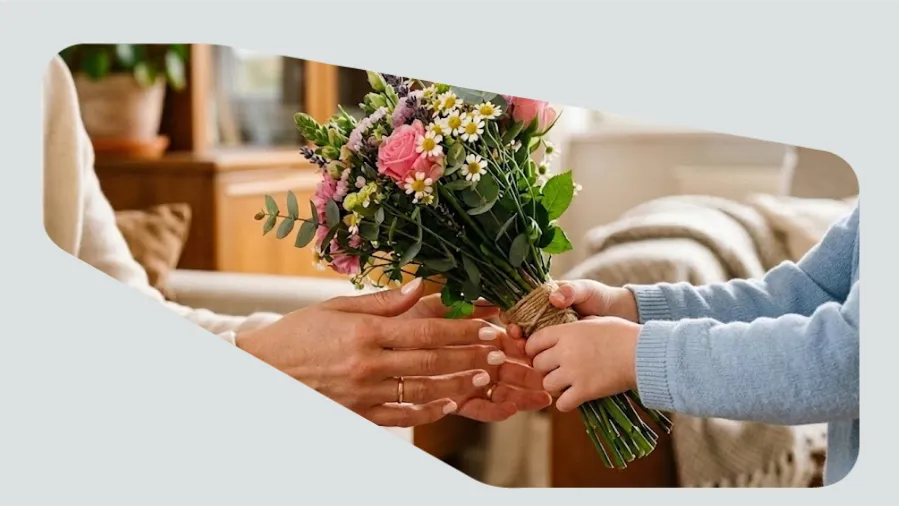 Filho dando um buquê de flores para a mãe no dia Das Mães